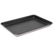 A black Vollrath Wear-Ever non-stick rectangular bun / sheet pan with a metal wire rim on a counter.