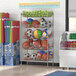 A Regency stationary retail display stand with 5 baskets full of balls and sports equipment.