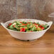 A GET Olympia melamine bowl filled with salad with tomatoes and lettuce.