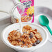 A bowl of Kellogg's Raisin Bran cereal with milk and a spoon.