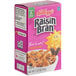 A pink and white Kellogg's Raisin Bran cereal box.