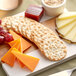 A cheese and crackers board with Carr's Table Water Original Crackers on a table.