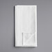 A folded white napkin on a gray surface.