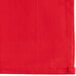 A red cloth napkin with a stitched white border.