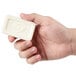 A hand holding a white bar of Dial soap.