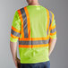 A man wearing a Cordova lime high visibility safety vest with reflective tape.