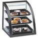 A Cal-Mil Midnight Bamboo display case with pastries on it.