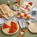 An Acopa light oak faux wood melamine serving board with pizza, bread, and cheese on it.