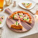 An Acopa faux wood melamine serving board with a pizza on it.