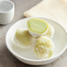 Green tea and white rice cake balls in a white bowl.