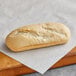 A case of Turano mini baguette rolls on a cutting board.