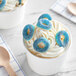 A cup of ice cream with Kervan blue raspberry gummy rings on top.