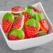 A bowl of Kervan strawberry and cream gummy candies with red and green fruit.