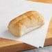 A sliced Turano French roll on a white surface.
