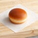 A Turano sweet brioche hamburger bun on a wooden surface.