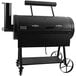 A black Old Country BBQ Pits direct flame grill with wheels.