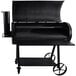A black Old Country BBQ Pits direct flame grill with a table and wheels.