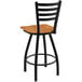 A Holland Bar Stool Jackie restaurant bar stool with a black frame and medium maple seat.