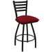 A Holland Bar Stool Jackie Ladderback swivel bar stool with black wrinkle finish and a red cushion with a graph pattern.
