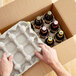 A person opening a Lavex Molded Fiber 12 Bottle Upright Soda / Beer Shipper box with a tray of beer bottles.