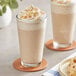 Two glasses of Frozen Bean Caramel Latte blended ice coffee with whipped cream and caramel topping.