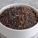 A bowl of Davidson's Organic Tropical Flower loose leaf tea with colorful flowers.