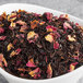 A bowl of Davidson's Organic Rose Congou loose leaf tea with dried flowers.