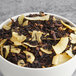 A bowl of Davidson's Organic Coconut Chai loose leaf tea with brown and white chips.