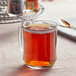 A glass mug of Davidson's Organic Tulsi Red Vanilla tea on a table.