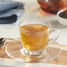 A glass cup of Davidson's Organic Tulsi Pure Leaves tea on a wooden surface.