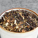 A bowl of black and brown Davidson's Organic Lemon Essence with Peel Loose Leaf Tea.