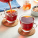 A glass cup of Davidson's Organic South African Rooibos Herbal Loose Leaf Tea on a table.