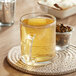 A glass mug of Davidson's Organic White Spicy Raspberry tea on a table.