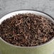 A bowl of Davidson's Organic Pu-erh Black loose leaf tea on a table.