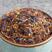 A bowl of Davidson's Organic Winter Fruit and Flowers herbal loose leaf tea with dried herbs, fruit, and flowers.
