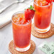 Two glasses of red Davidson's Organic Strawberry Iced Tea with strawberries on top.