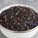A bowl of Davidson's Organic Russian Caravan black tea with blue and purple petals.