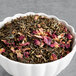 A bowl of Davidson's Organic Jasmine Rose loose leaf tea with dried flowers.