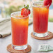 Two glasses of Davidson's Organic decaf strawberry iced tea with strawberries on the rim.