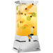 A Rosseto clear plastic beverage dispenser with fruit in it on a stainless steel base.