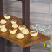 A Cal-Mil Madera rustic pine shelf with small pastries on it.
