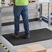 A man standing on a black Choice anti-fatigue floor mat.
