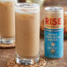 A glass of iced coffee with a can of Rise Brewing Co. Organic Oat Milk Vanilla Nitro Cold Brew Coffee.