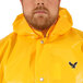 A man wearing a yellow Tingley rain jacket with a black eagle on the hood.