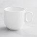 An Acopa Cordelia bright white porcelain cup with an embossed design and a handle.