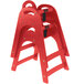 A red plastic Koala Kare high chair with black straps.