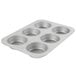 A silver Chicago Metallic mini muffin pan with six muffins in it.