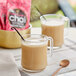 Two glass mugs of David Rio Flamingo Vanilla Decaf Sugar-Free Chai Tea Latte with a vanilla stick in one.
