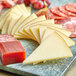 A plate of sliced Santa Marta Manchego-style cheese with meat.