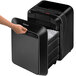 A hand pressing a Fellowes Powershred LX180 black cross-cut paper shredder.